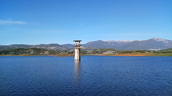 Lone concrete tower in Lake Canterno with mountains