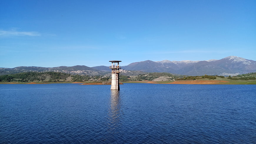 Lone concrete tower in Lake Canterno with mountains