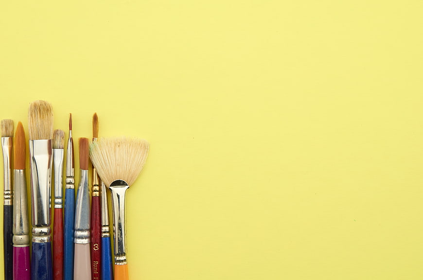 Paintbrushes on Yellow Background with Copyspace