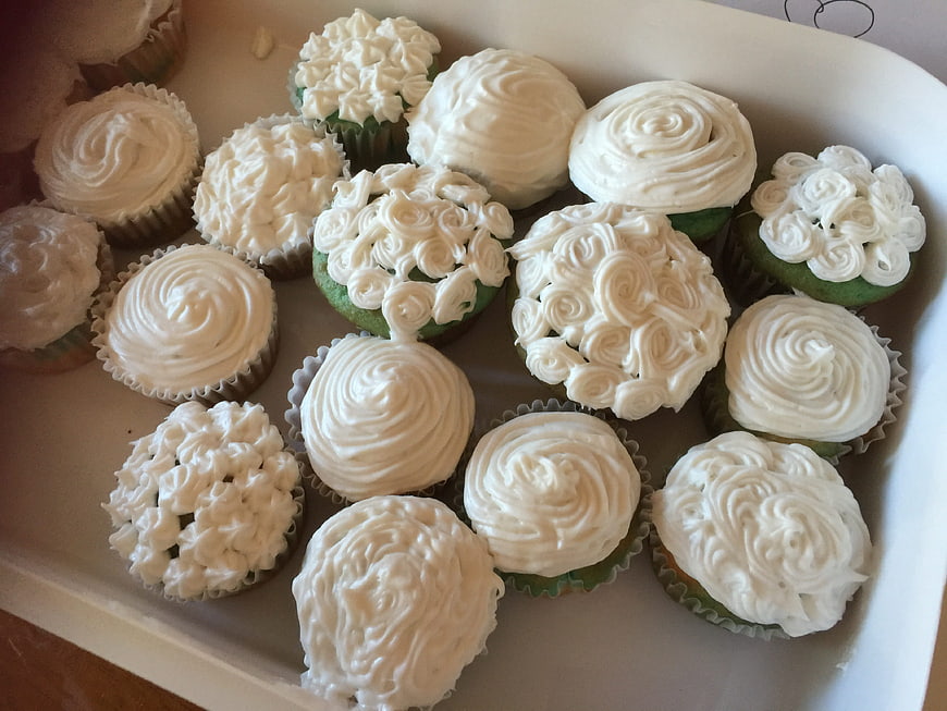 Tray of homemade cupcakes with white frosting swirls