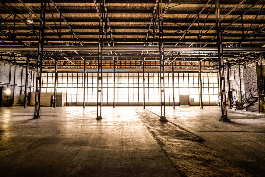 Vast Abandoned Industrial Factory Interior With Steel Beams And Concrete Floor