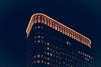 Modern Curved Office Building at Night with Warm Lights