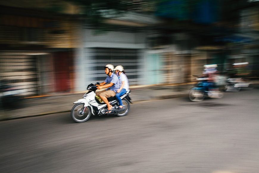 Couple Riding Motorcycle on Blurred City Street