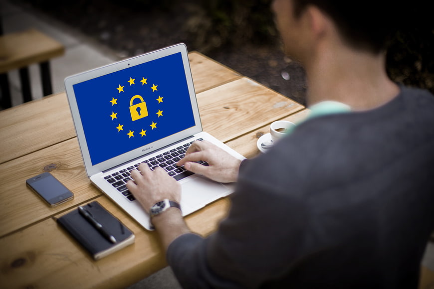 Man typing on laptop with EU flag and lock icon