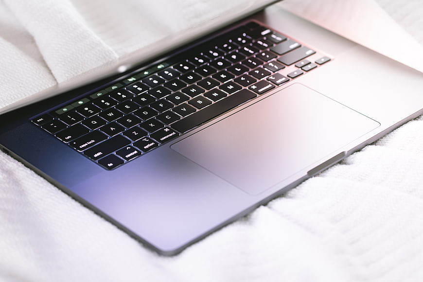 Close-up of Silver Laptop on White Bedding