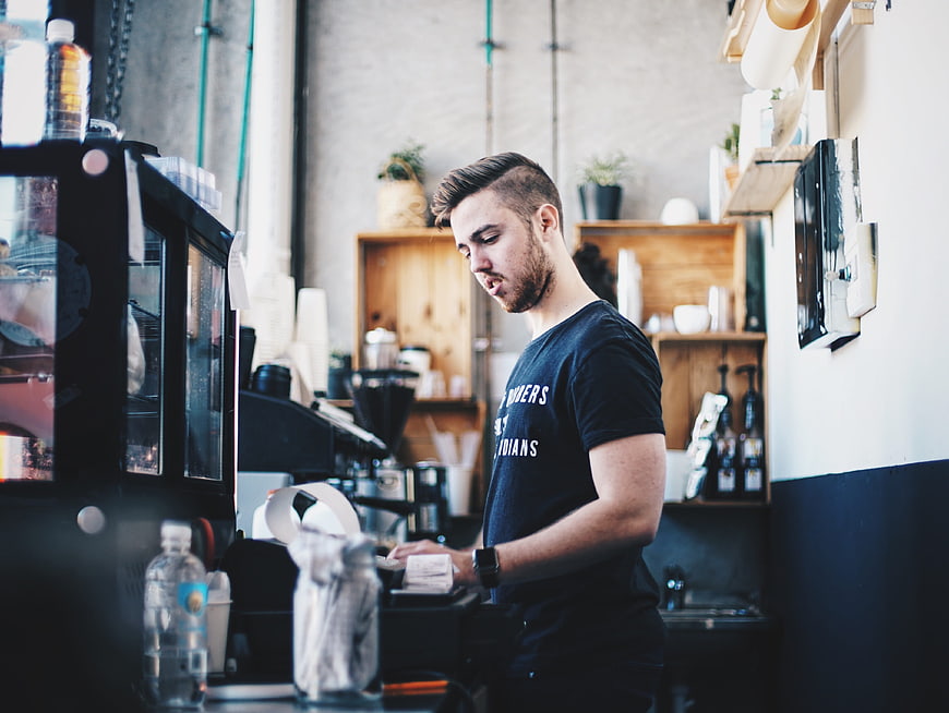 Bearded barista working at a modern cafe counter