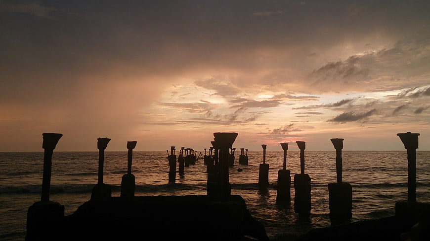 Silhouetted Sea Pillars Against Dramatic Sunset Sky
