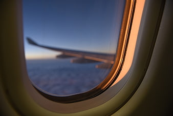 Airplane Wing View Through Window at Sunset