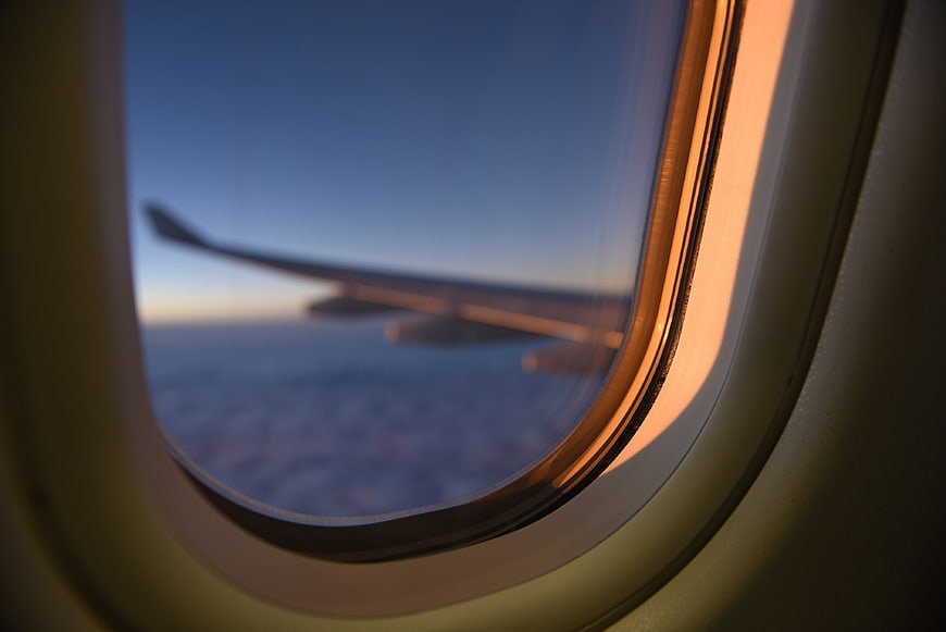 Airplane Wing View Through Window at Sunset