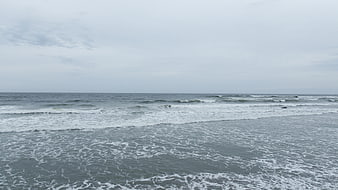 Gray ocean waves rolling on a cloudy overcast day