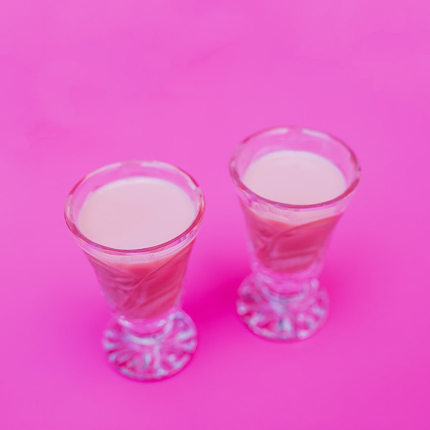 Two Pink Cocktail Shots on Vibrant Pink Background