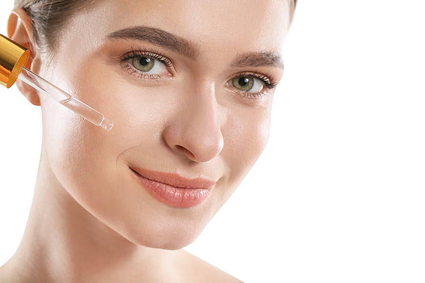 Woman Applying Serum Dropper to Face for Skincare