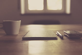Minimalist workspace with coffee, notebook, and smartphone
