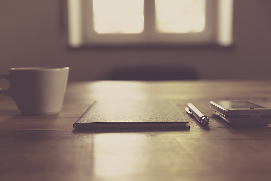 Minimalist workspace with coffee, notebook, and smartphone
