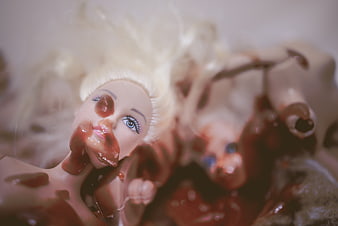 Horror doll covered in fake blood close up