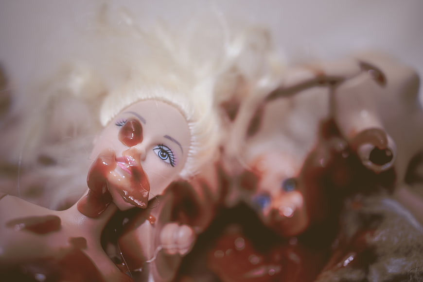 Horror doll covered in fake blood close up