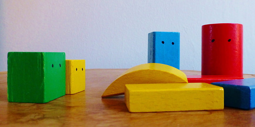 Colorful Wooden Building Blocks With Faces On Table