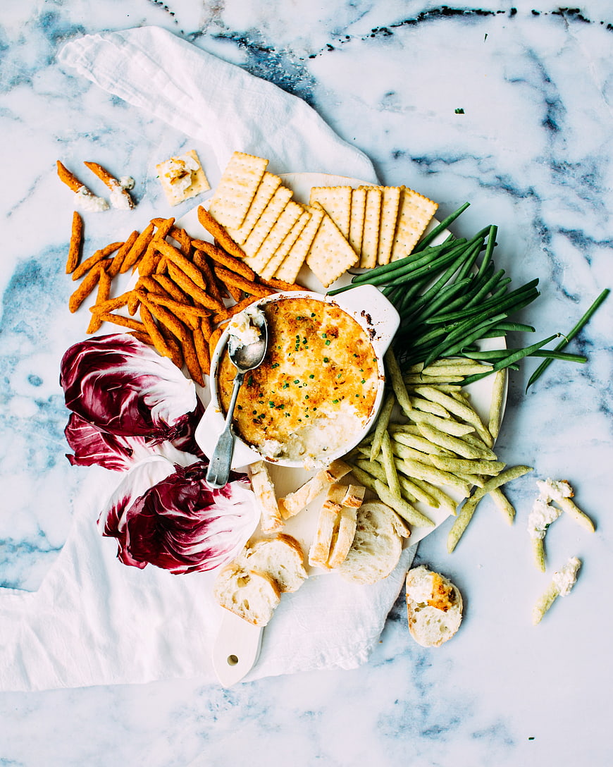 Overhead view of cheese dip platter with crackers and vegetables