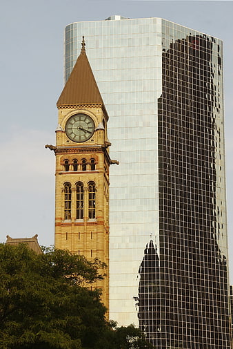 Historic Clock Tower Reflected in Modern Glass Skyscraper