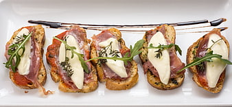 Gourmet Bruschetta Appetizer With Prosciutto, Mozzarella, And Arugula