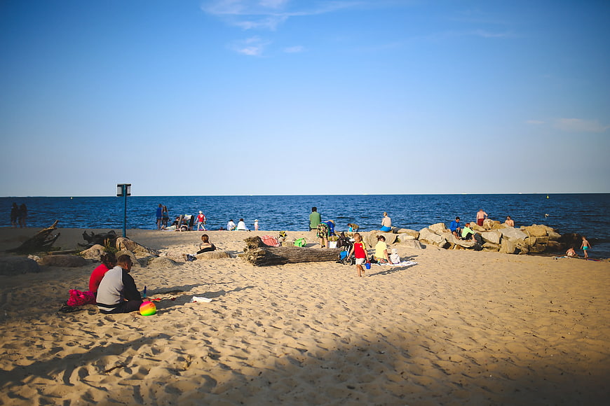 People relaxing on a sunny sandy beach with blue sea