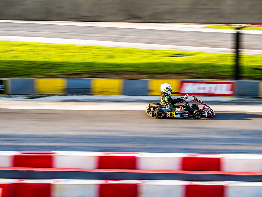 Go-kart racer speeding on track with motion blur background