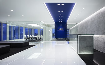 Modern corporate office interior with blue accent wall and glass meeting room