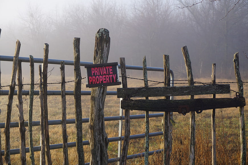 Private Property Sign on Rustic Wooden Fence in Foggy Field