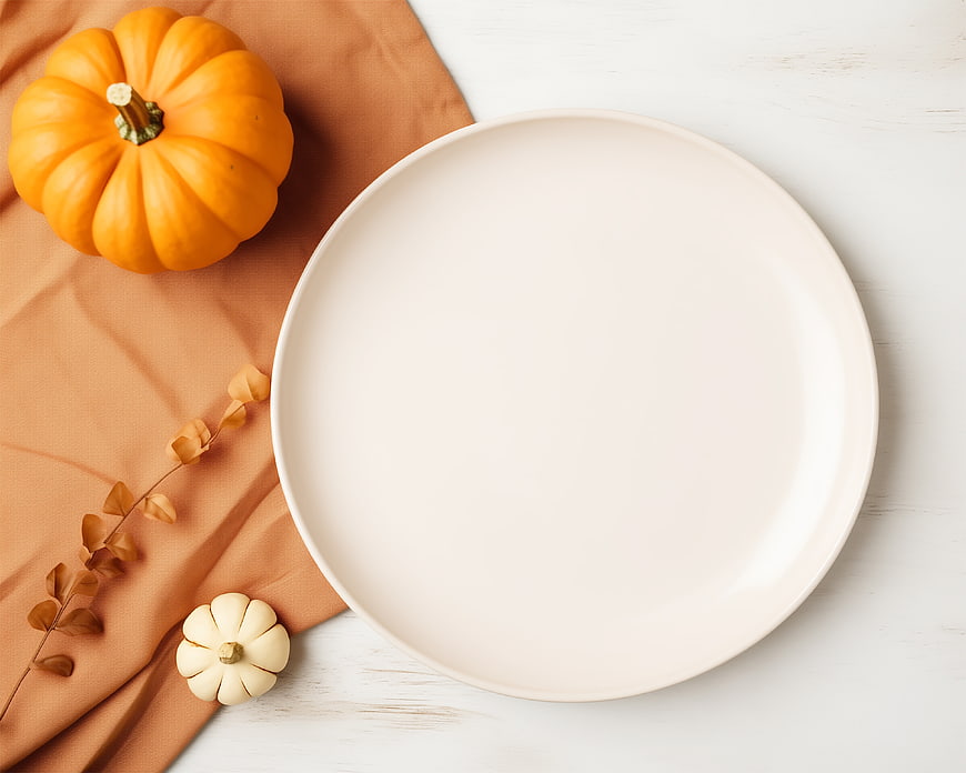 Autumn flat lay with empty plate and pumpkins on white table