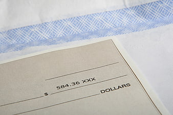 Close-up of a check with amount 584.36 on white envelope