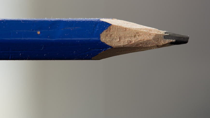 Close-up of a blue pencil tip on a gray background
