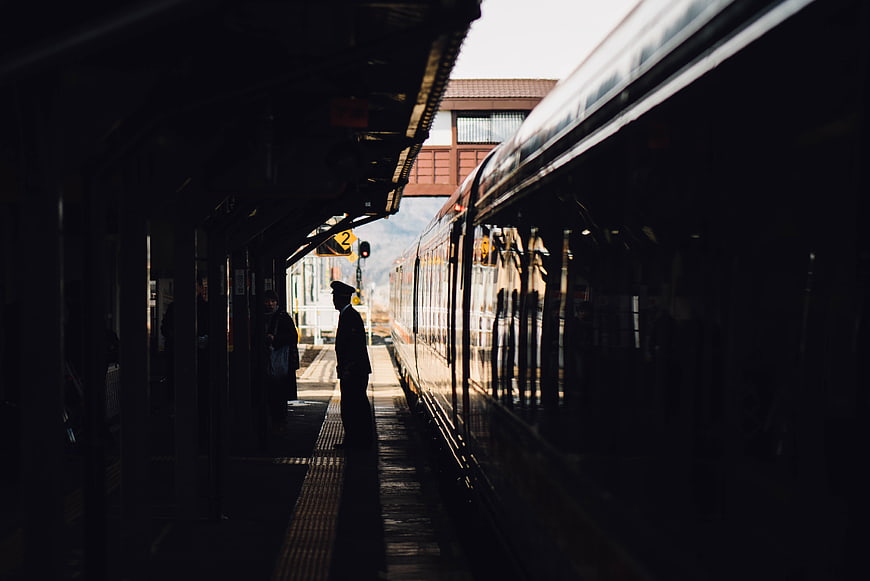 Silhouette of train conductor on station platform
