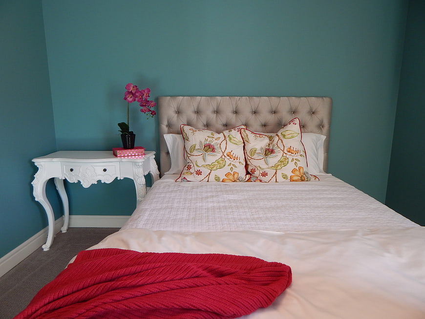 Cozy Bedroom with Teal Walls and Red Throw Blanket