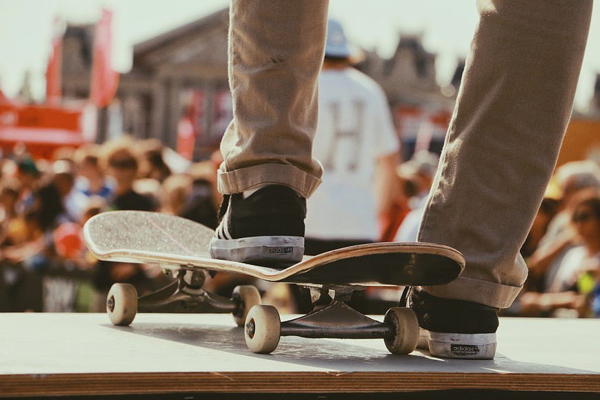 Skateboarder Feet on Ramp with Crowd Background
