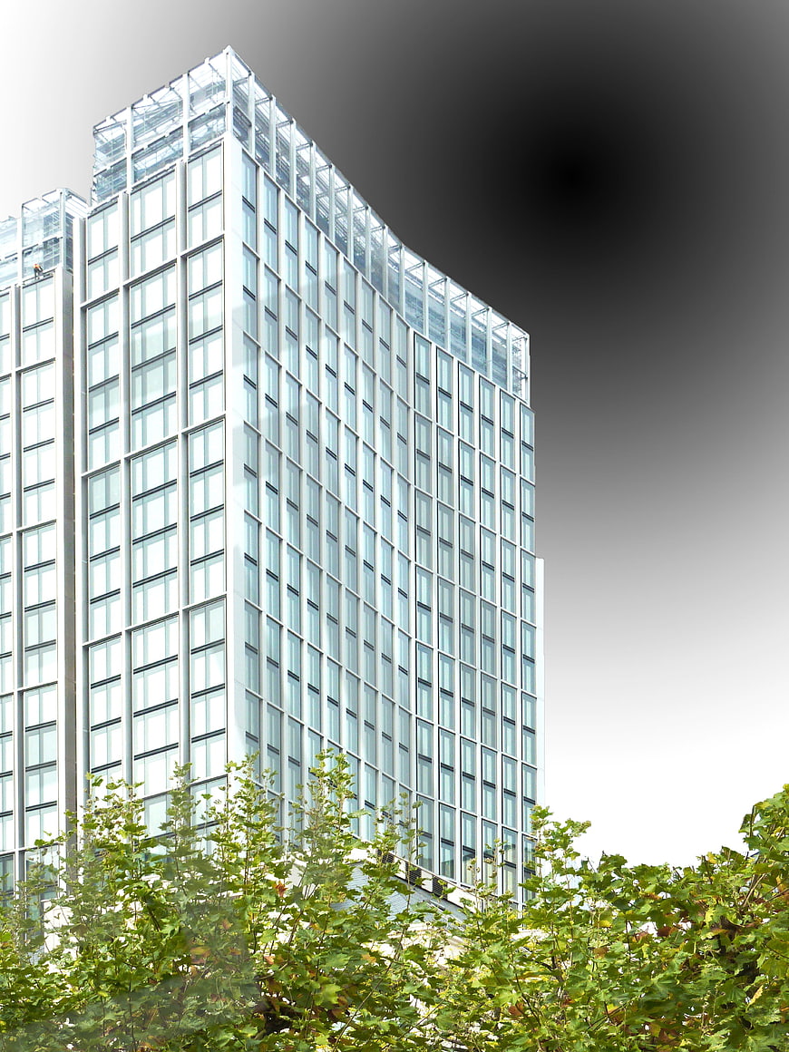 Modern Glass Skyscraper with Green Trees in Foreground