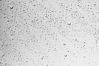 Black and white raindrops on glass window texture background