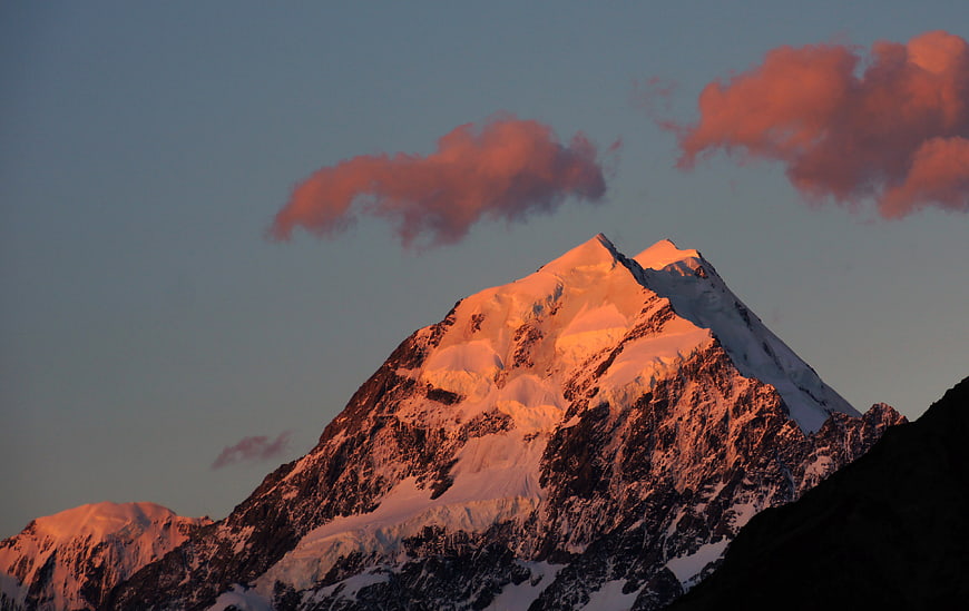 Snowy Mountain Peak with Pink Clouds at Sunset