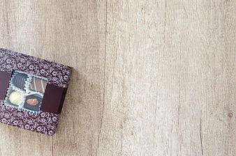 Box of assorted chocolates on light wooden background