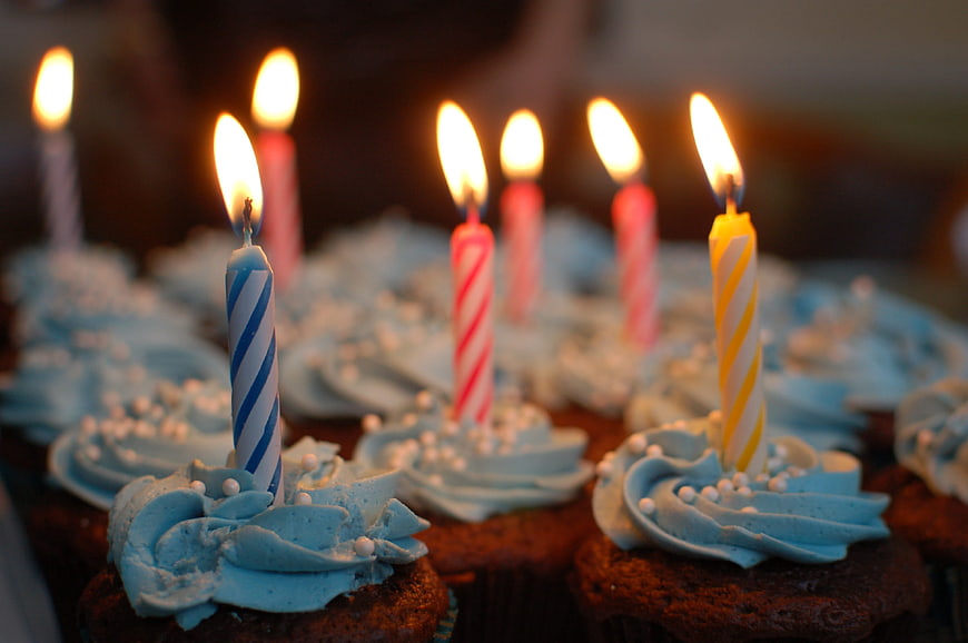 Chocolate Cupcakes with Blue Frosting and Lit Birthday Candles
