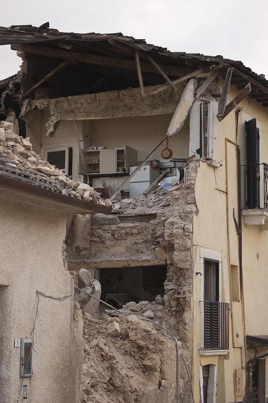 Collapsed House After Earthquake With Exposed Kitchen Interior And Rubble