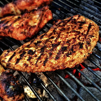Close-up of grilled chicken breasts on charcoal grill