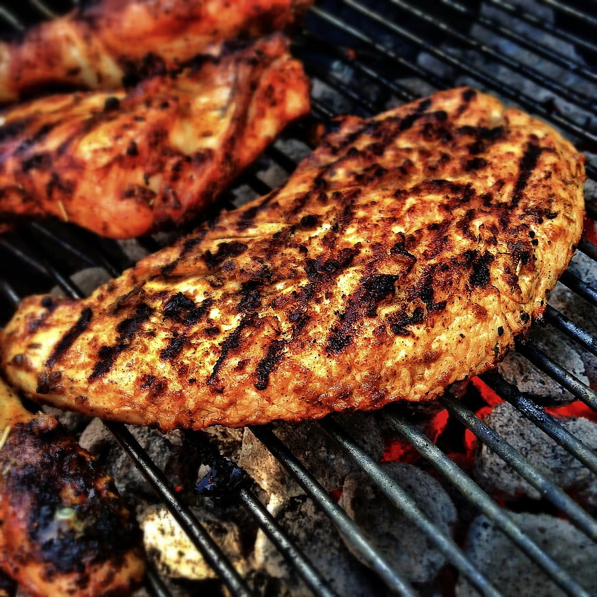 Close-up of grilled chicken breasts on charcoal grill