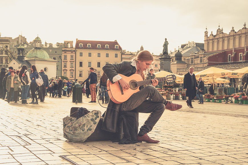 Street Musician Playing Guitar in Historic European Square