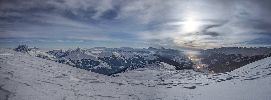 Panoramic Winter Mountain Landscape with Snowy Peaks and Valley Lights