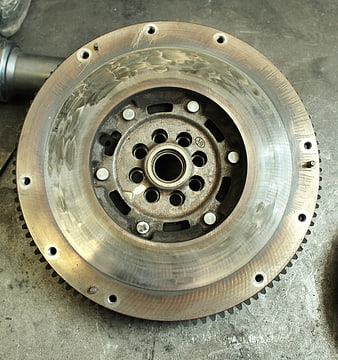 Automotive Flywheel Sprocket Close Up On Concrete Workshop Floor