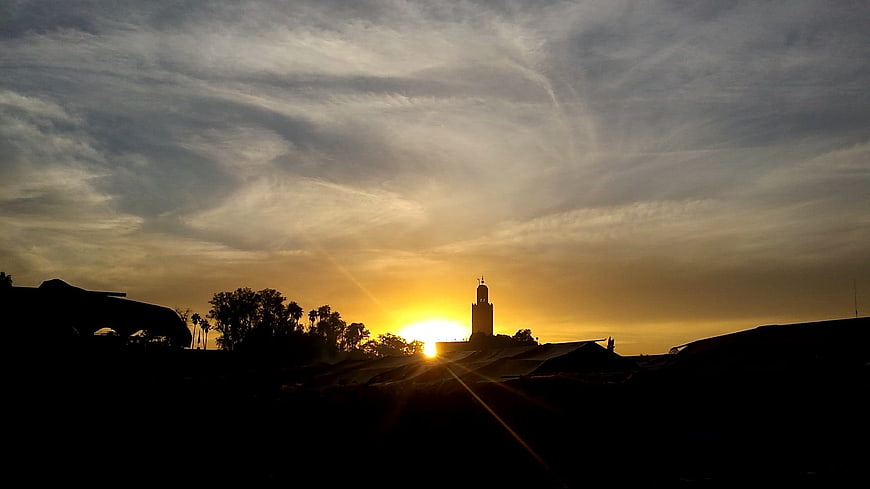 Silhouette of Mosque Minaret Against Golden Sunset Sky