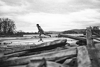 Skateboarder riding through a construction site in black and white