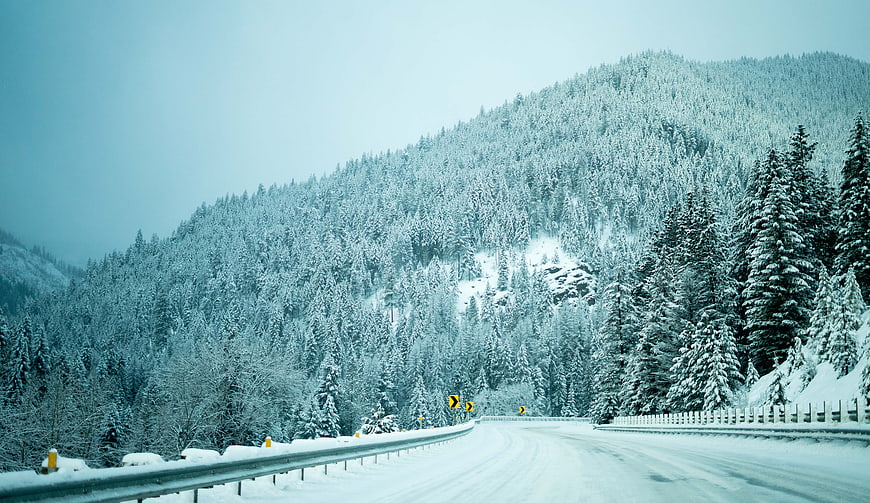 Snowy Mountain Road Winding Through Winter Forest