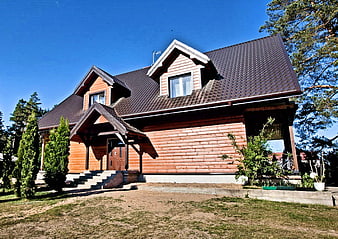Modern wooden house with dark roof and garden
