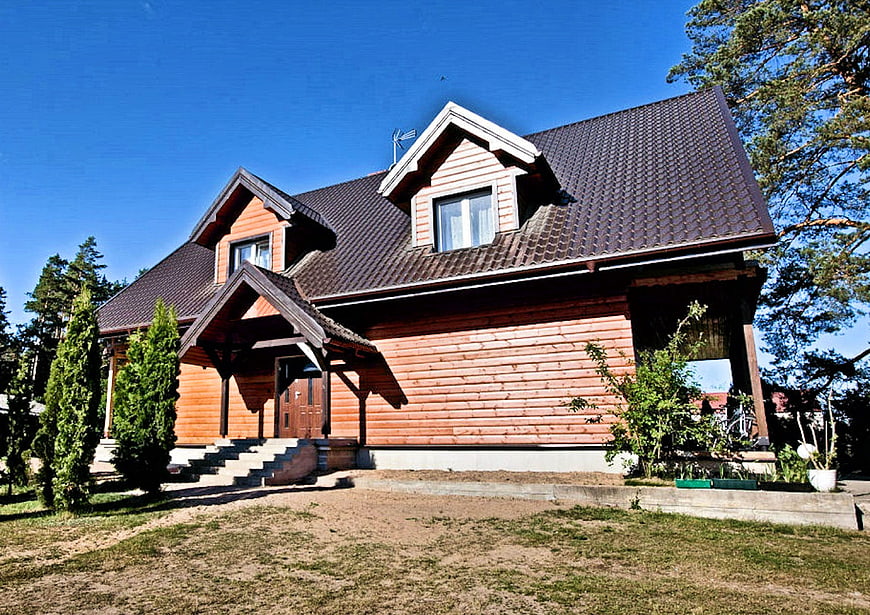 Modern wooden house with dark roof and garden